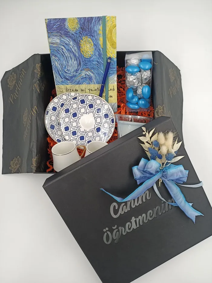 Öğretmenler Günü için Canım Öğretmenim yazılı siyah hediye kutusu, defter, kahve fincanı ve mavi şekerlerle